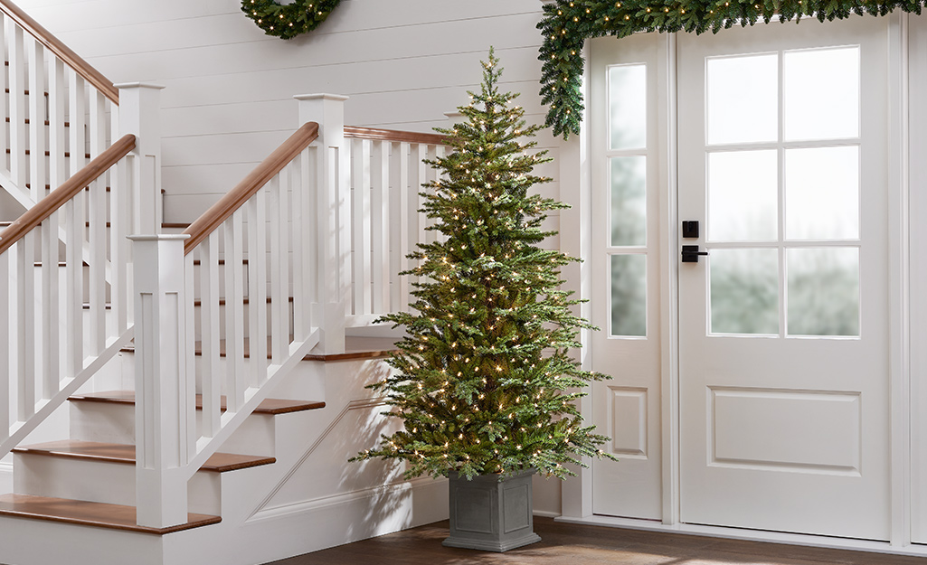 An artificial potted Christmas Tree in an entryway.
