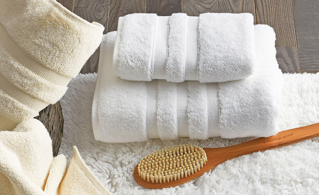 Egyptian cotton towels placed next to a bath brush.
