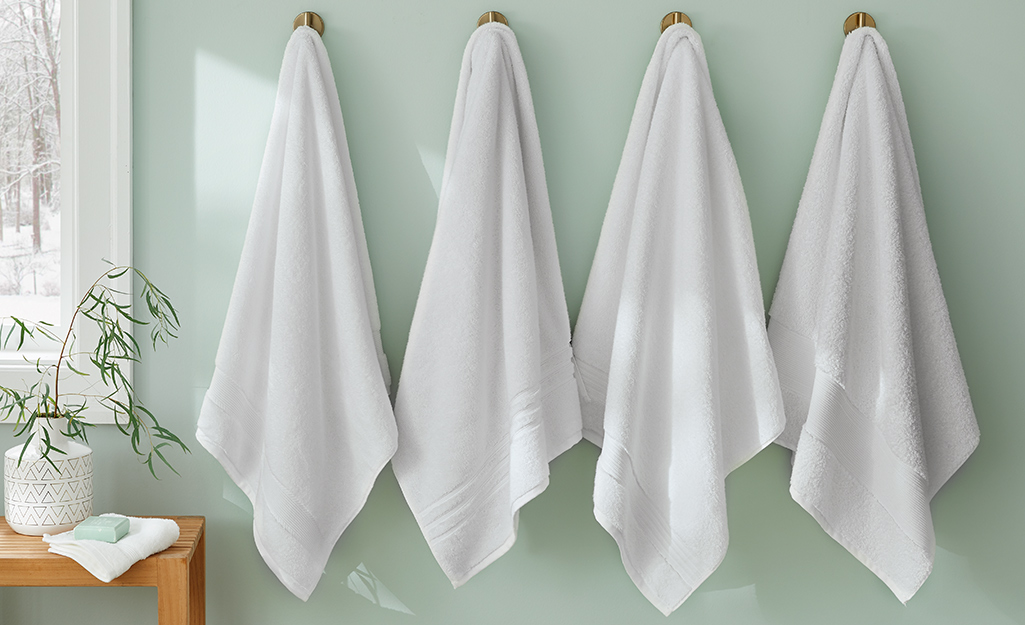 Towels hung on hooks in a bath.