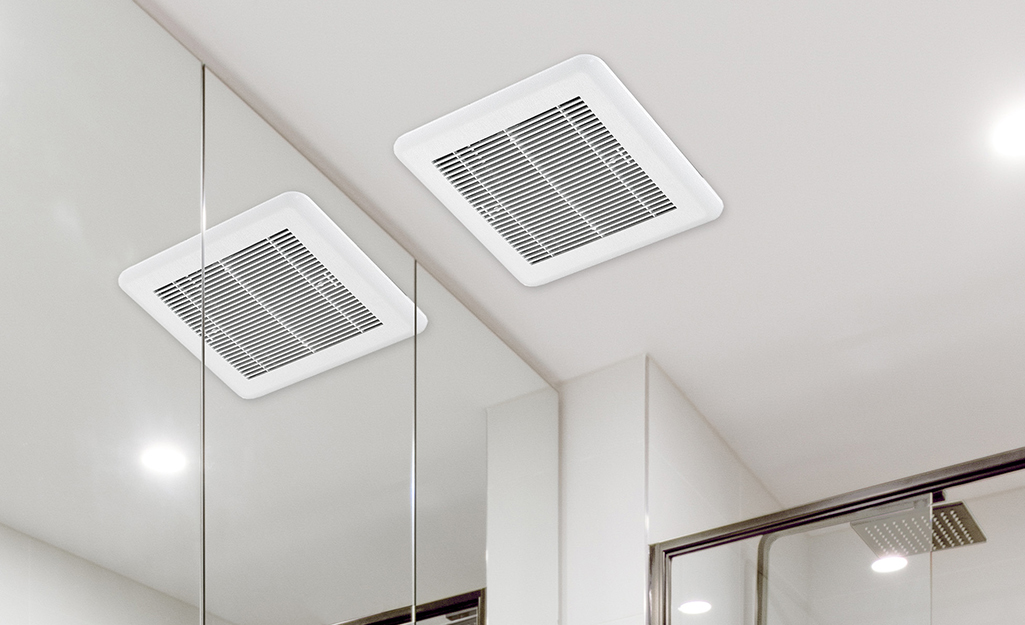 A ceiling bath fan reflected in a bathroom mirror.