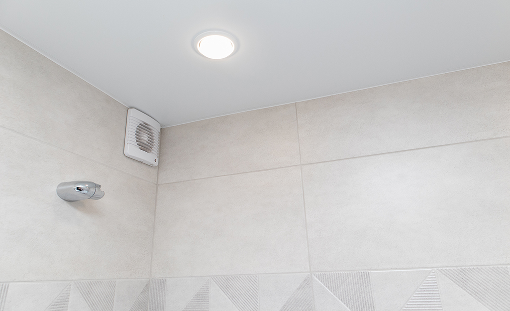 A wall bath fan in the top corner of a bathroom.