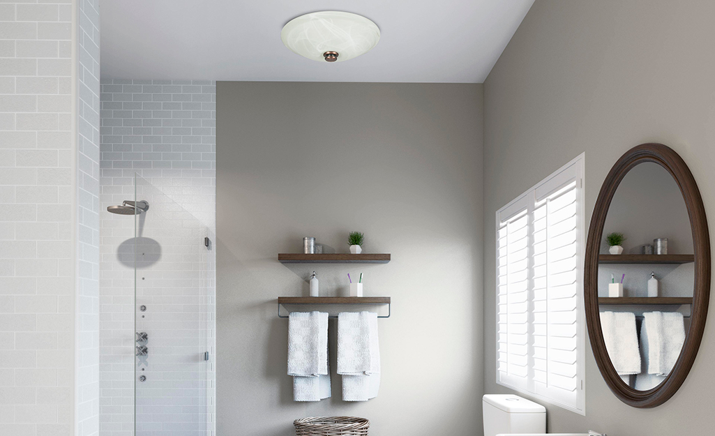 A decorative bathroom fan with a built-in light and glass globe.