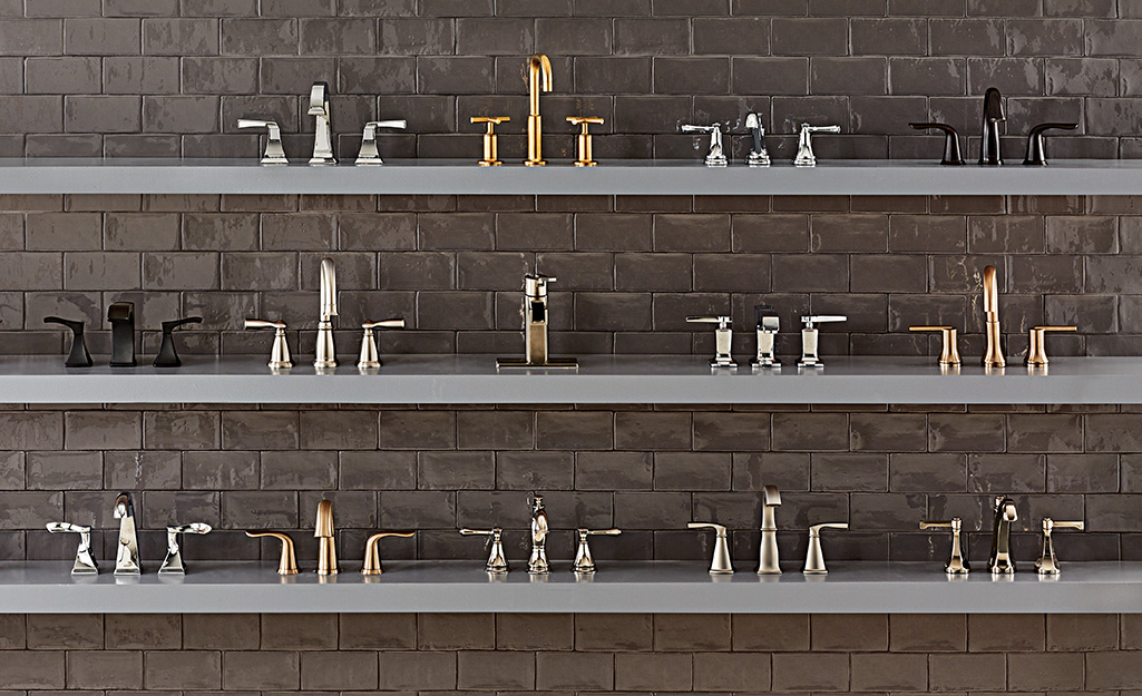 Three shelves holding a display of bathroom faucets in different styles and finishes. 