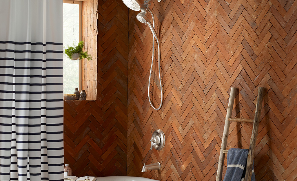 A wall mounted shower head with a handheld feature on a unique tile background.