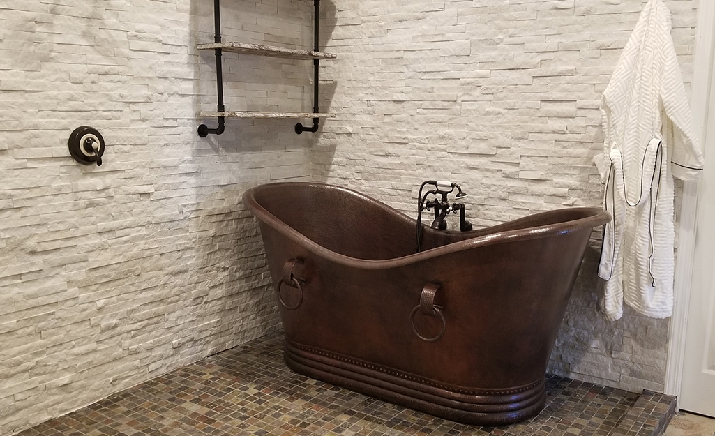 Copper bathtub in a small bathroom.