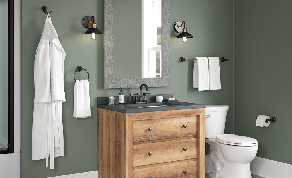 A bathroom vanity with a mirror, toilet roll holder, robe hooks, towel rinks, and towel racks.