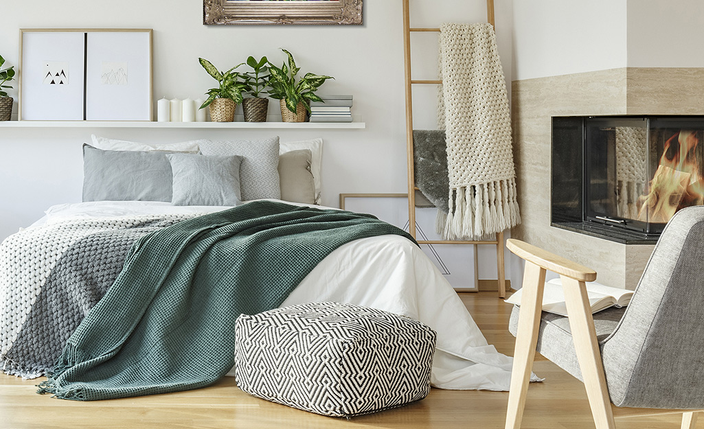 A bed made with delicate, green and gray blankets. 