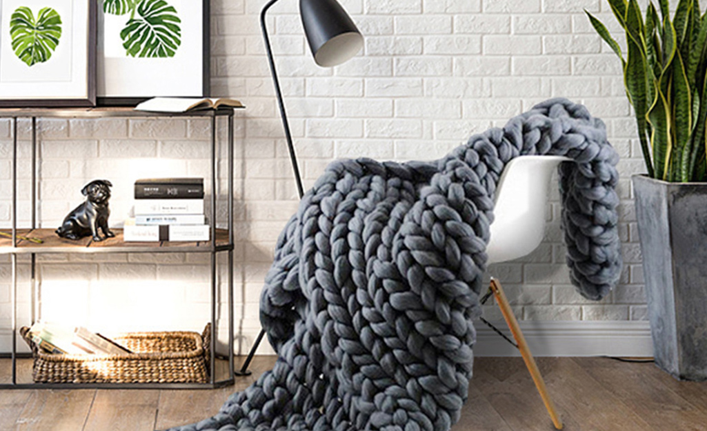 A gray knit throw on a chair.