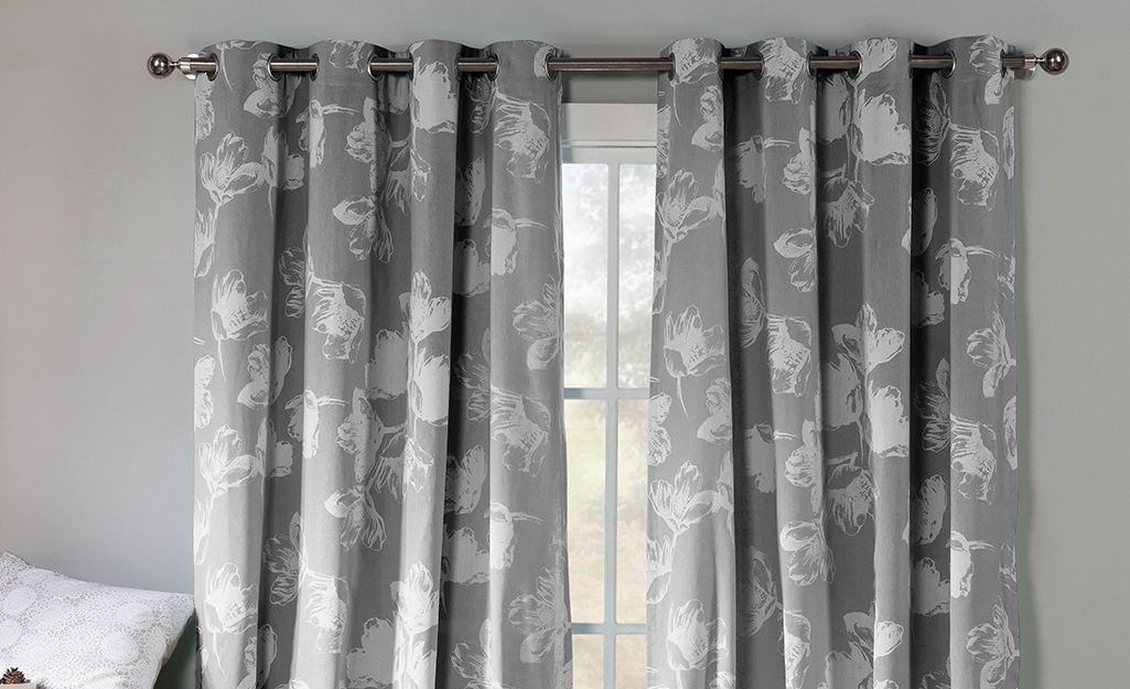 A pair of grommet drapes in a window.