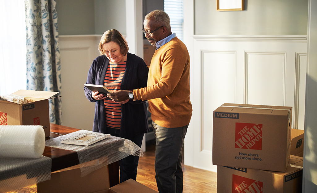 Couple checking off moving boxes in their new home.