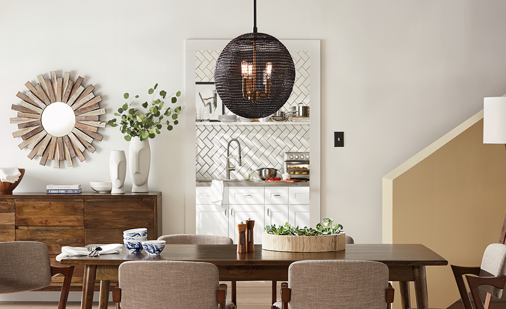A round bronze chandelier hangs in a dining room.