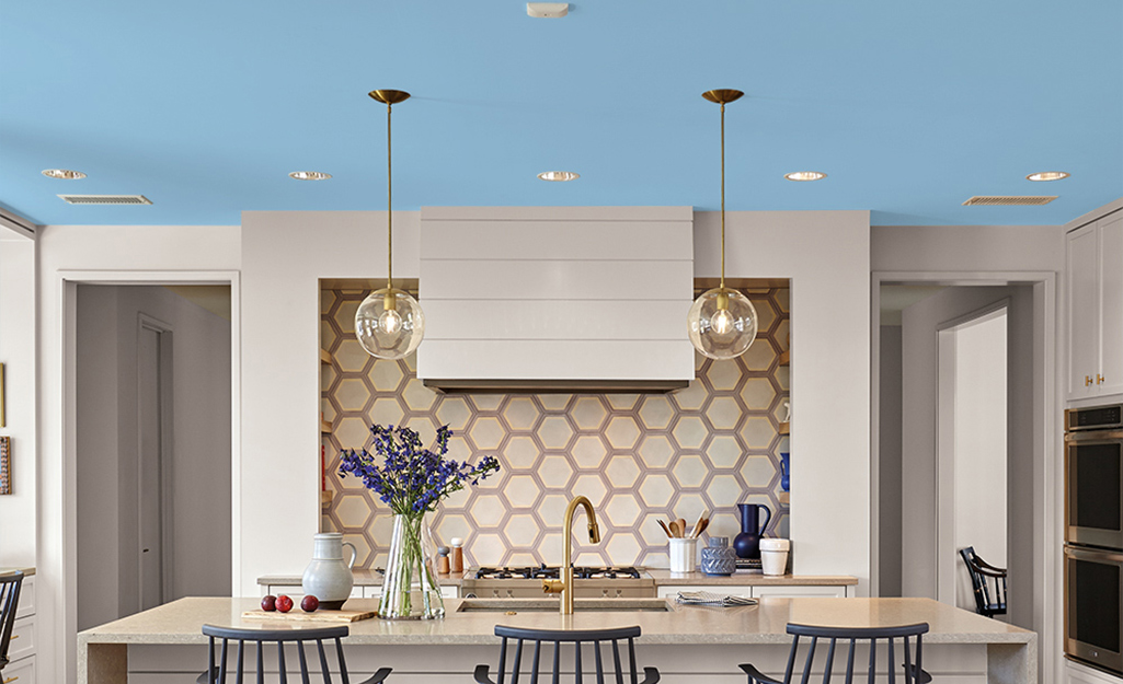 A modern kitchen featuring a light blue ceiling.