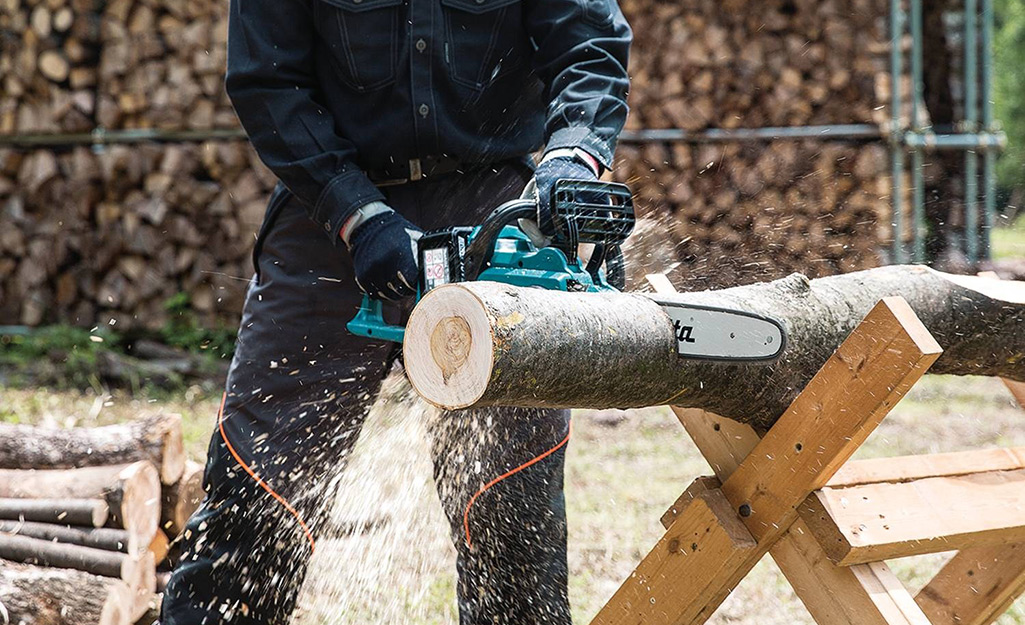 Someone using a cordless chainsaw.