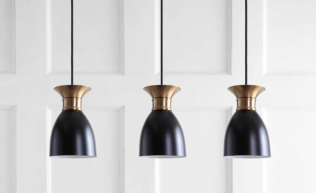 Three black and brass minimalist pendant lights.