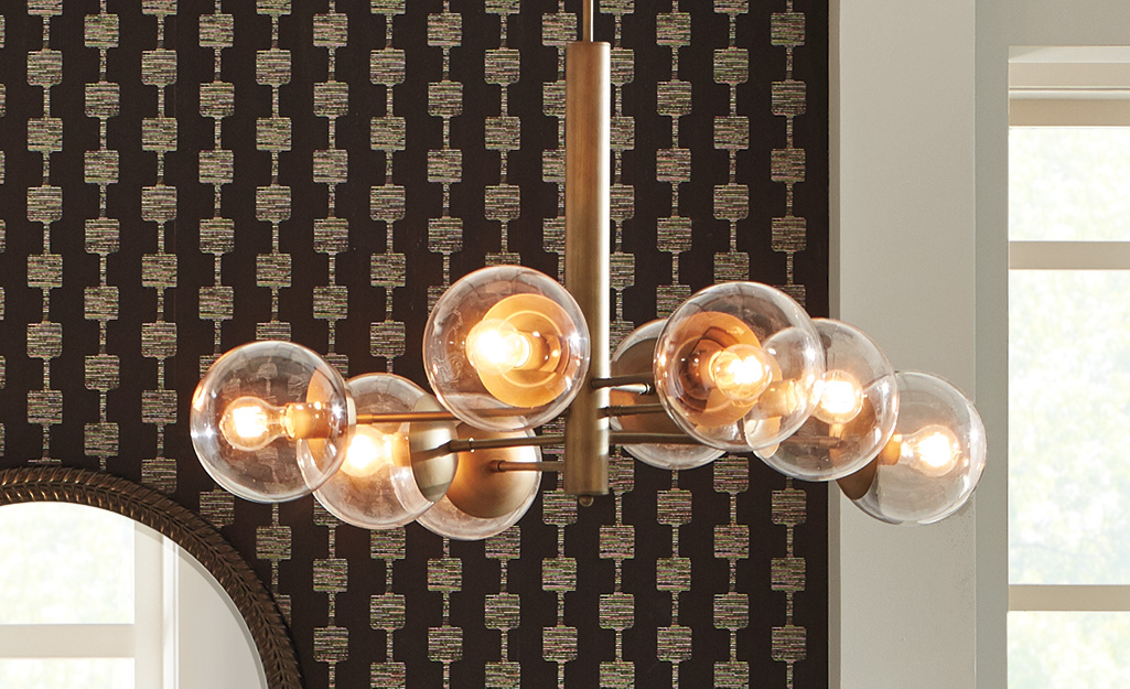 A modern chandelier with glass globes surrounding the bulbs.