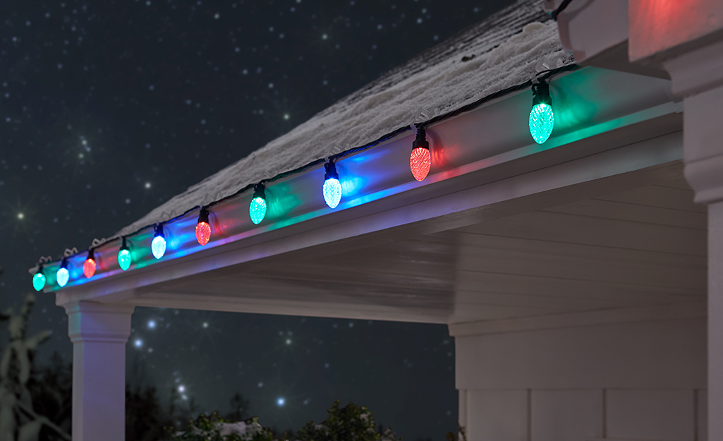 String Christmas lights hung on the eaves of a house.