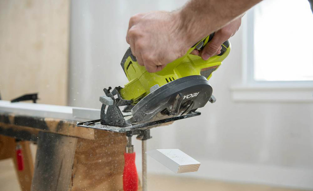 Man doing an angle cut on a board with a circular saw.