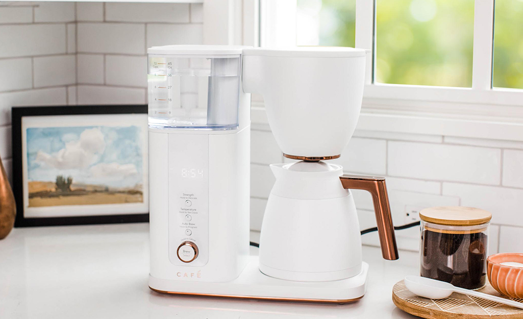 An white automatic coffee maker on a kitchen counter.