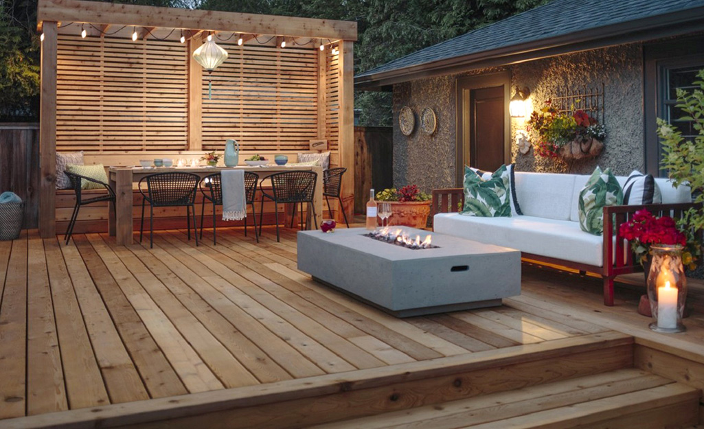 A cedar wood deck with a fire pit, pergola and outdoor eating space.