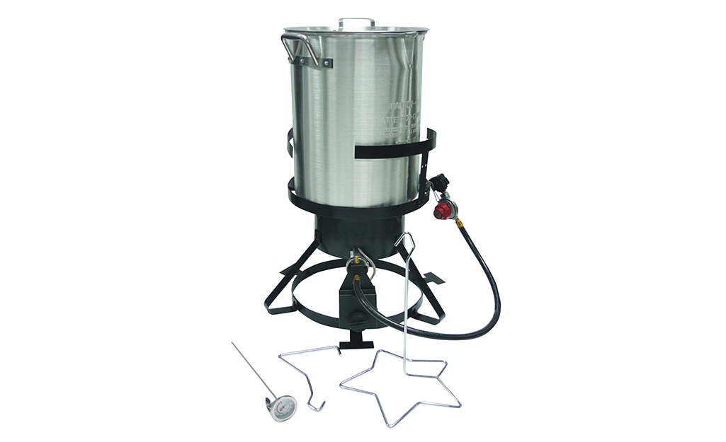 An outdoor deep fryer with a lid, lifting tool and removable thermometer.