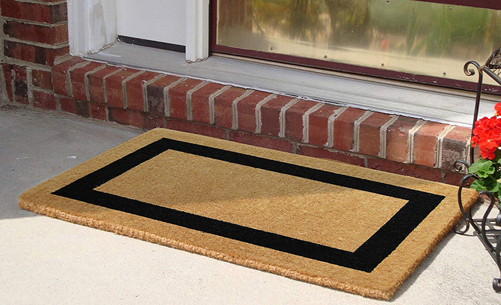 A coir doormat featuring a black rectangle.