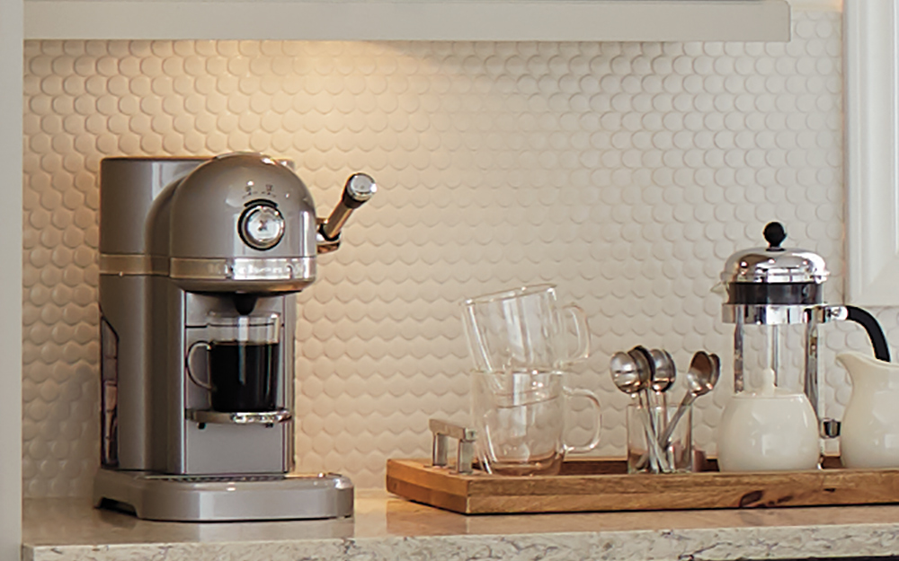 A home espresso machine and accessories on a kitchen countertop.