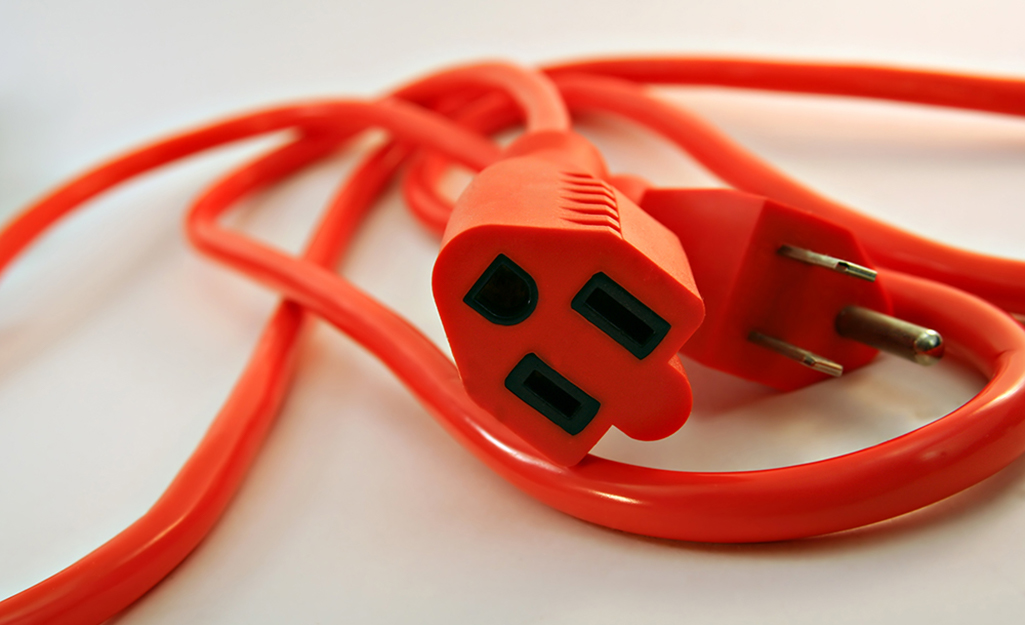 An orange extension cord featuring a three-prong end.