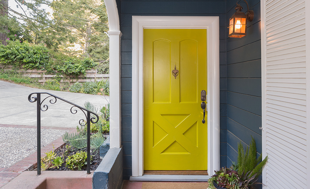 A front door painted yellow with a high-gloss finish.