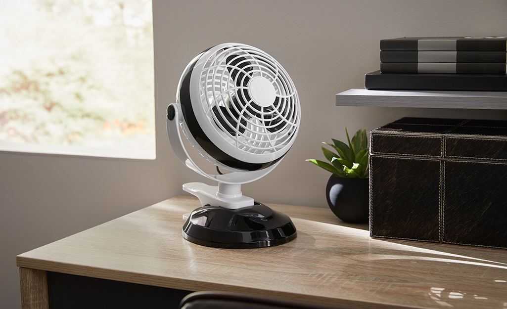 A personal fan positioned on a desk.