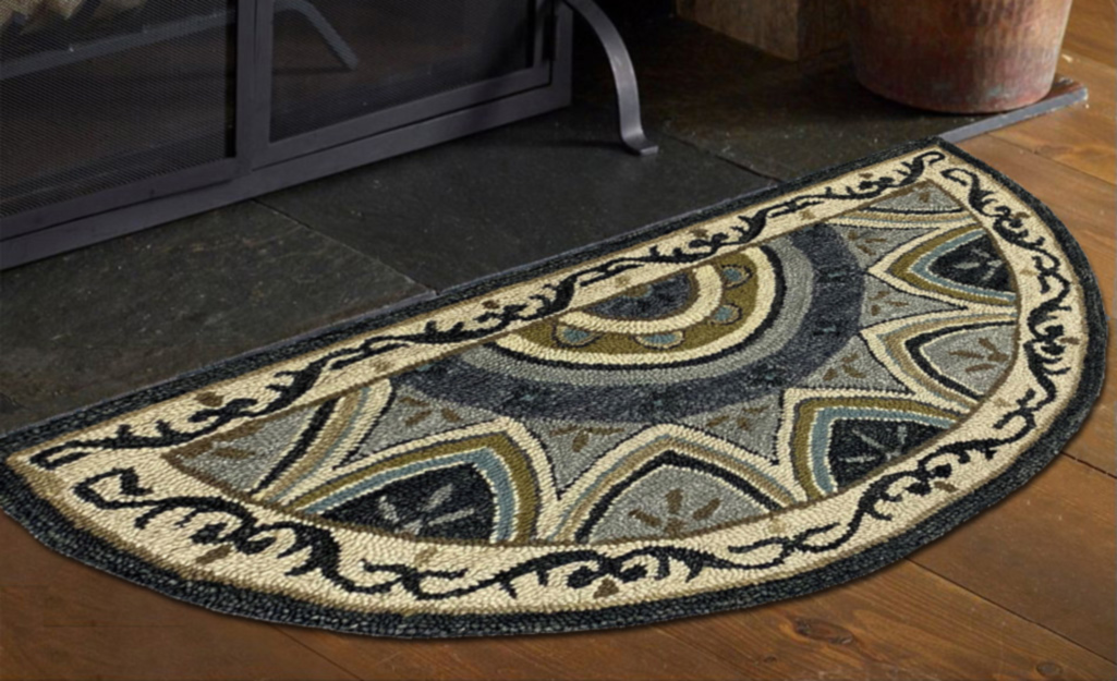 A decorative hearth rug next to a fireplace.