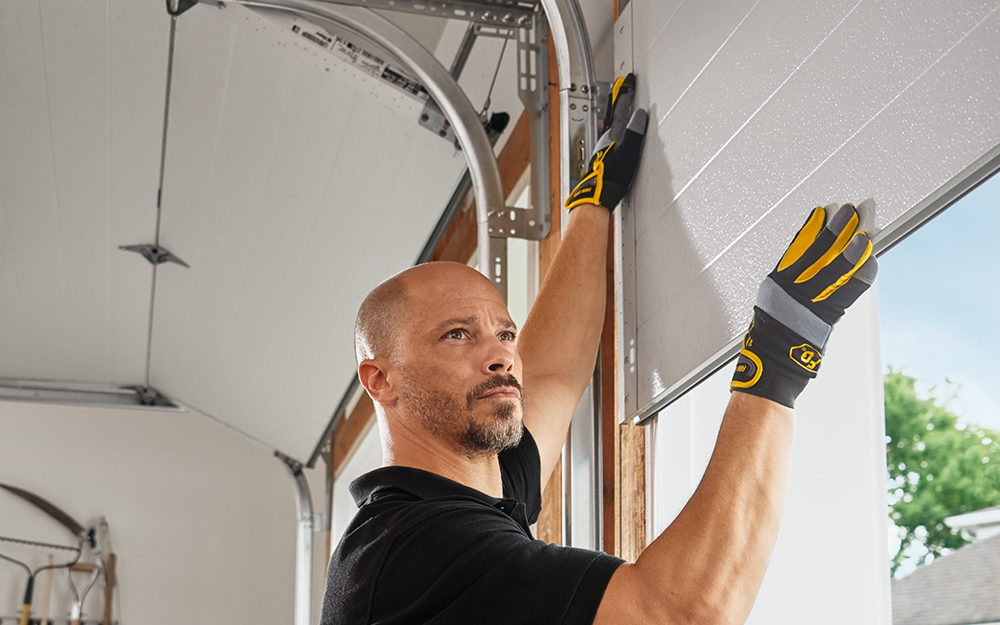 a man installing a garage door a man installing a garage door