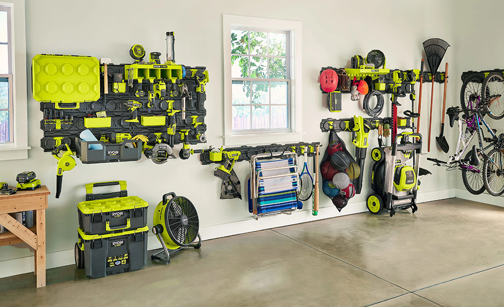 Power tools and other yard tools hang in a neatly organized garage.