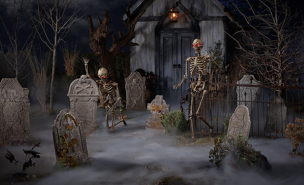 A front yard transformed into a creepy cemetery with tombstones and skeletons.