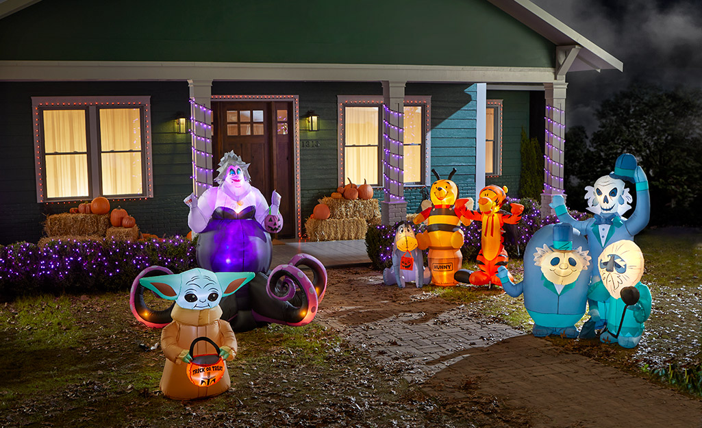 Ursula, Yoda and other scary Halloween inflatables filling a front yard.