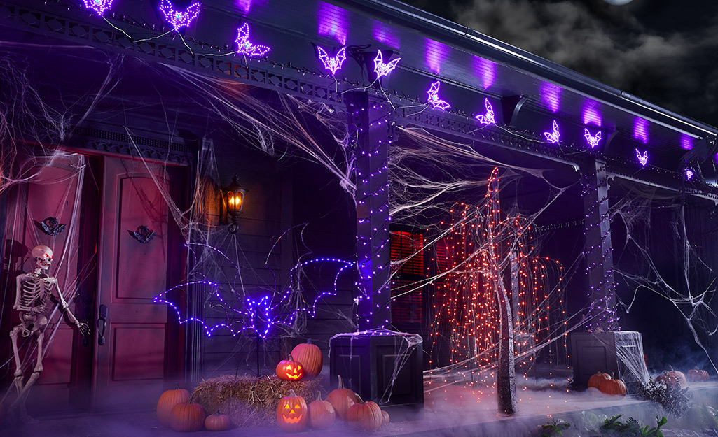 Strings of lights in orange and purple decorate a house for Halloween.