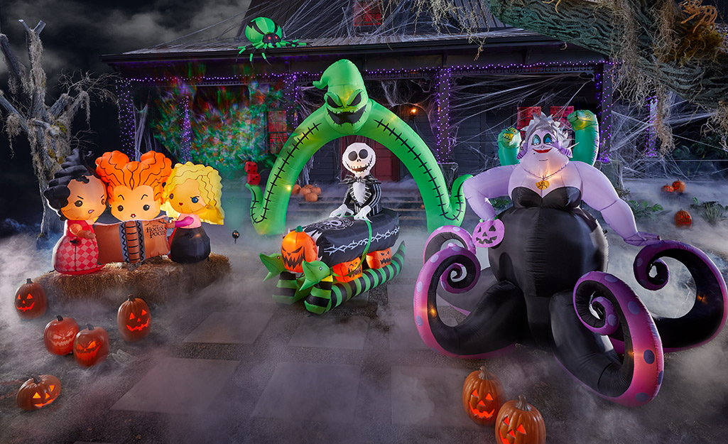 Inflatable versions of Ursula, Jack Skellington and the "Hocus Pocus" witches stand in a fog-filled yard decorated for Halloween.