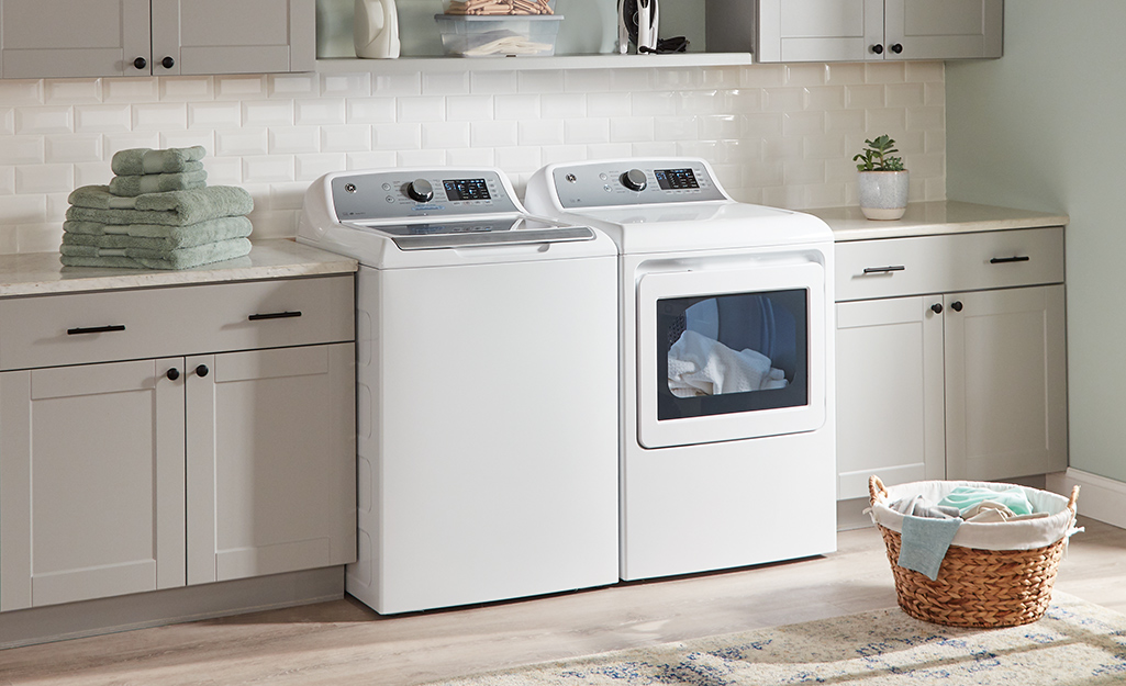 A white high-efficiency washer and dryer sitting side-by-side in a laundry room.