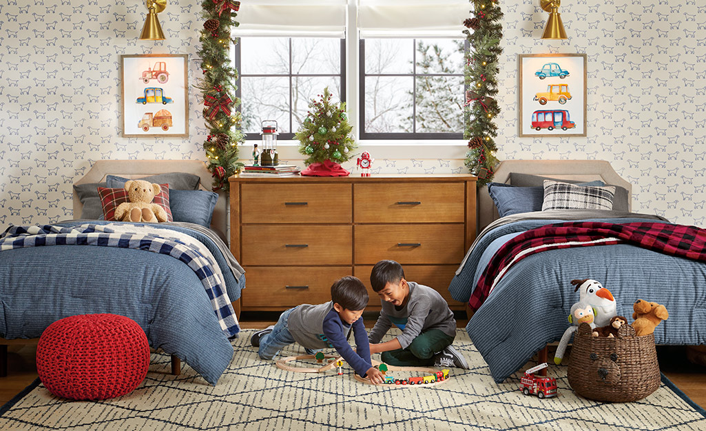 Kids playing on a bedroom floor.