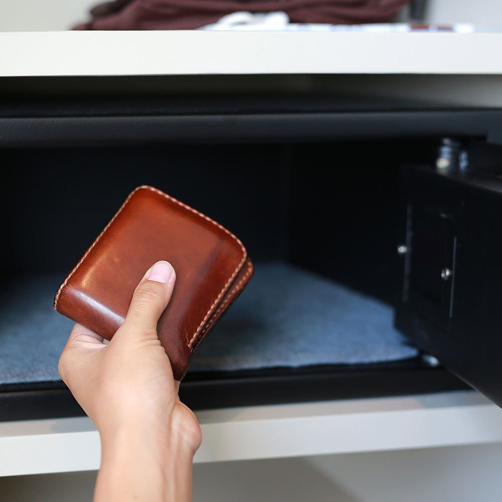 Person placing a wallet in a safe.