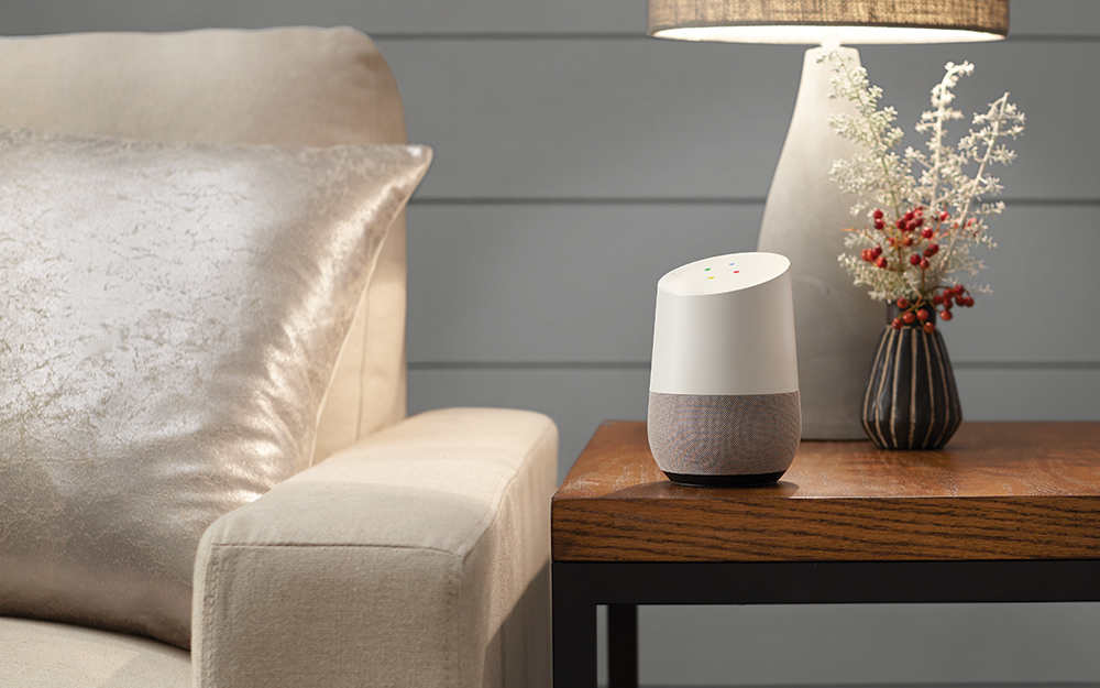 Google Home device on a table in living room. Google Home device on a table in living room.