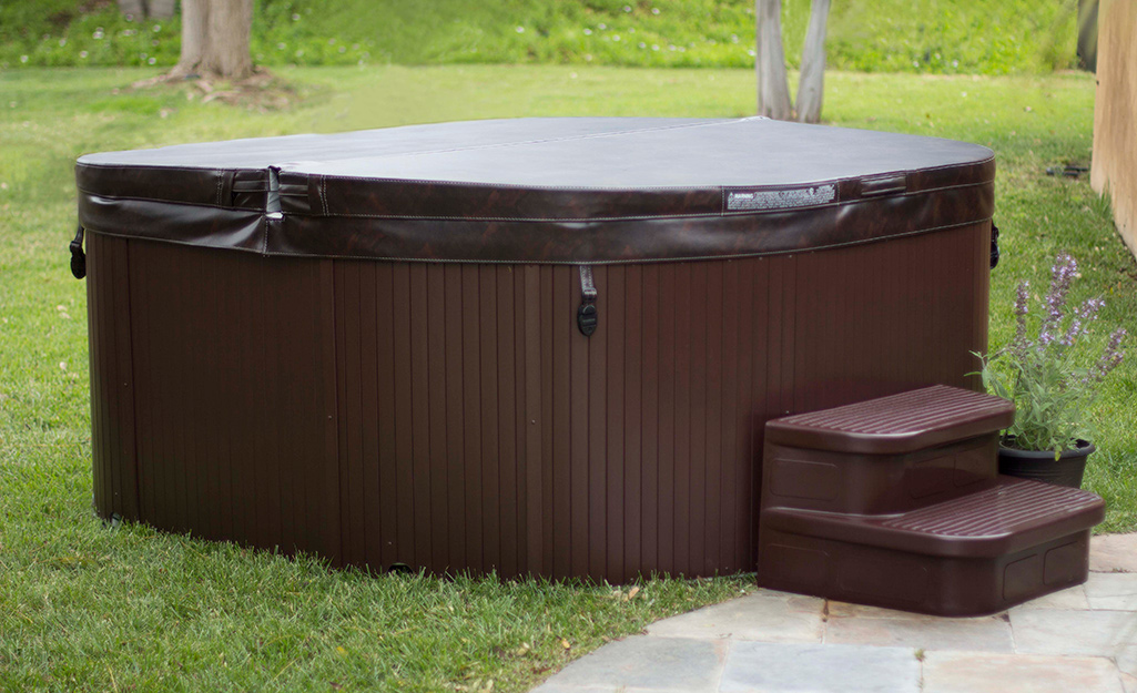 An outdoor hot tub covered with a protective top.