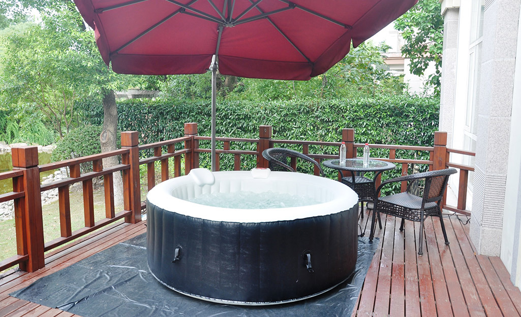 A round, inflatable hot tub placed on a deck.