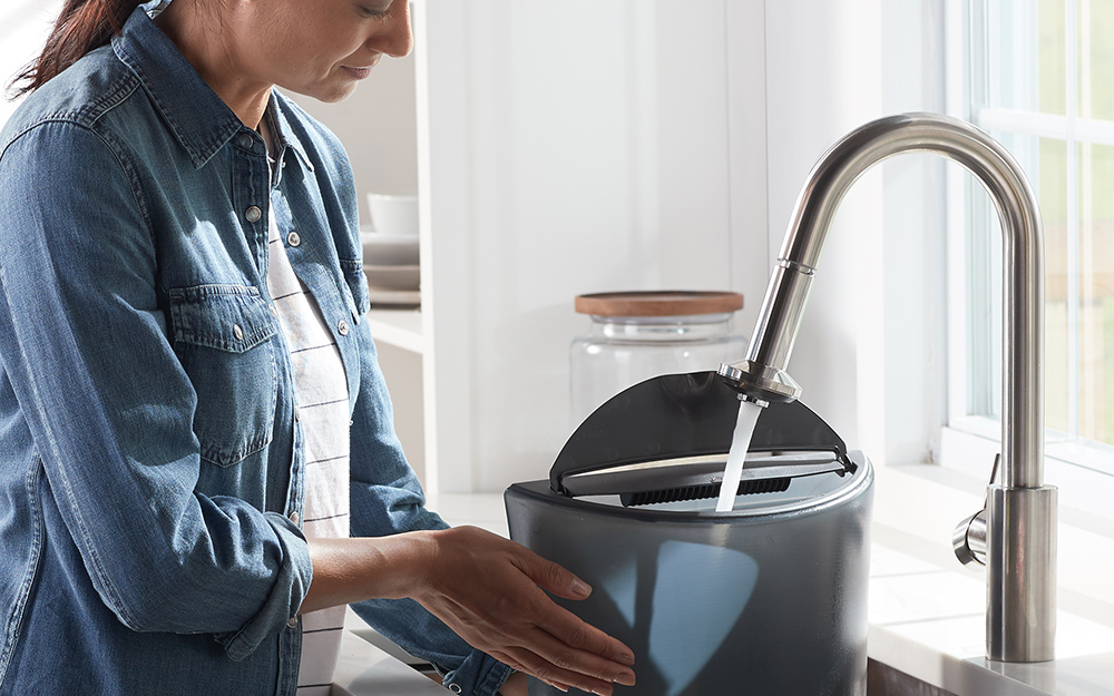 a woman refilling the water in a dehumidifier a woman refilling the water in a dehumidifier