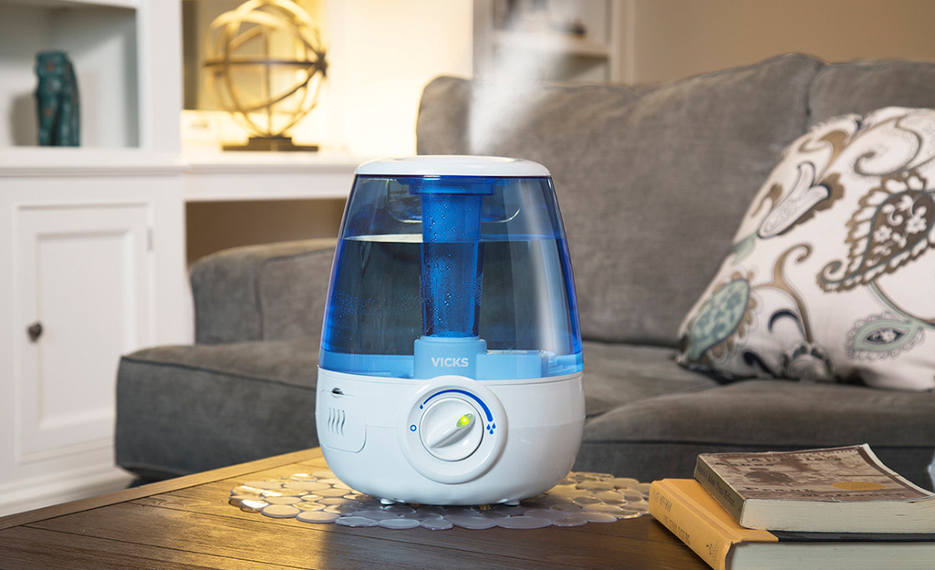 A cool mist humidifier sits on a coffee table in a living room. 