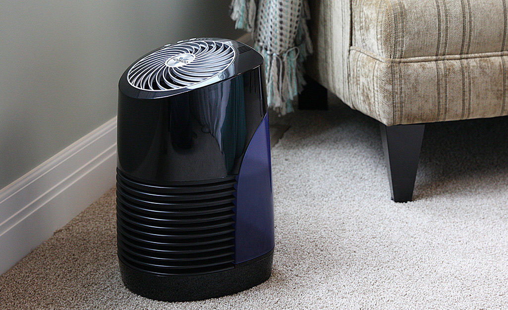 An evaporative humidifier placed next to a chair.