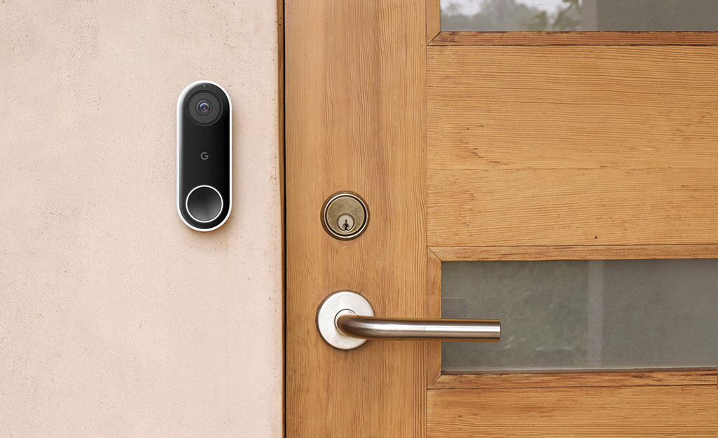 A smart doorbell and home intercom has been installed beside the door of a house.
