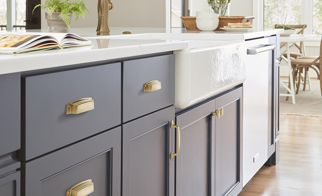 Cabinet doors and drawers with polished brass cabinet hardware.