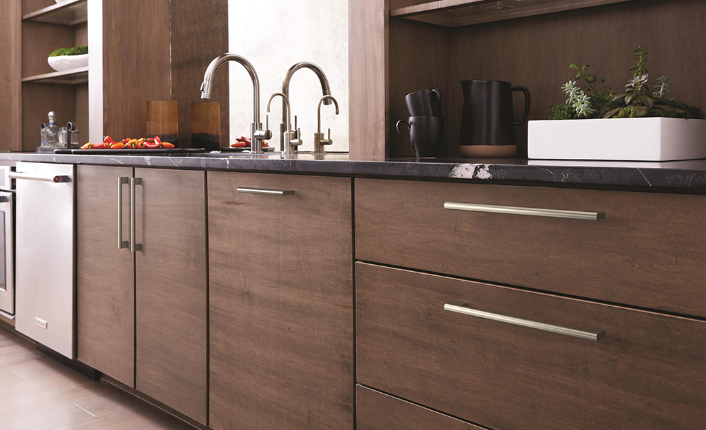 Brown kitchen cabinets with full overlay slab doors and drawers.