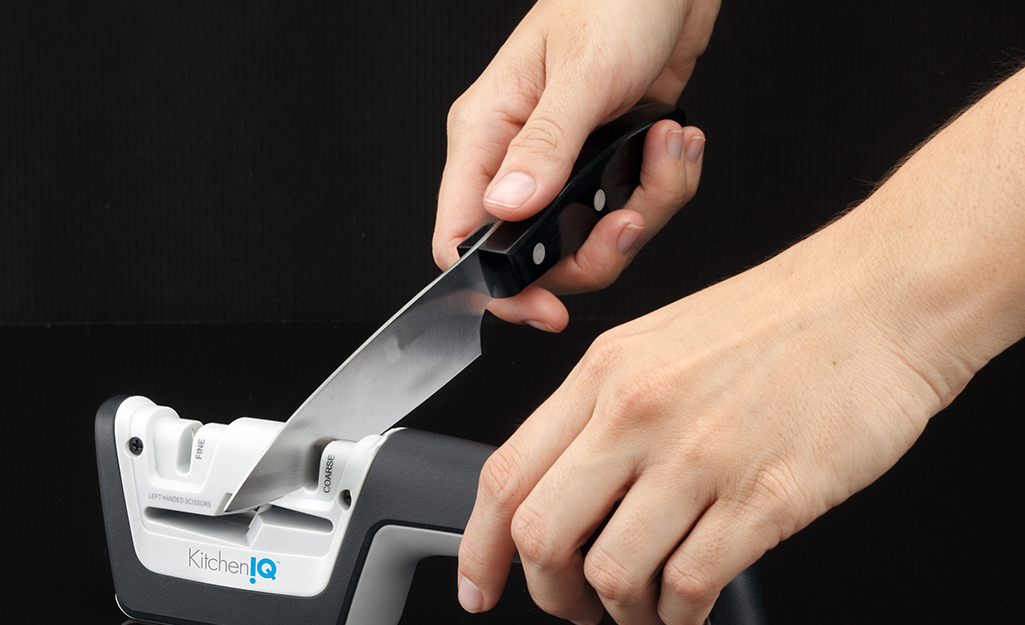 A person using a knife sharpener.
