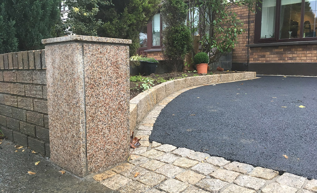 Block edging installed between a driveway and lawn.